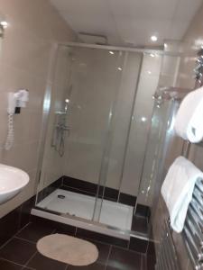 y baño con ducha y puerta de cristal. en Grand Hôtel De L'Europe, en París