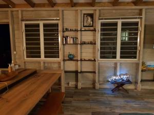 een woonkamer met een houten tafel en een open haard bij ZENALIZES bungalow calme et confortable in Le Moule