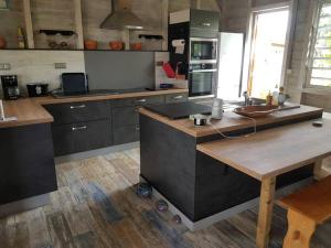 a kitchen with a wooden island in the middle at ZENALIZES bungalow calme et confortable in Le Moule