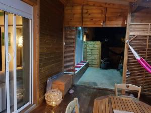 a porch of a wooden house with a table at ZENALIZES bungalow calme et confortable in Le Moule