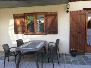 a wooden table and chairs in front of a house at Appartement Le Cembro in Crest-Voland