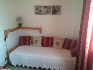 1 dormitorio con 1 cama con almohadas rojas y blancas en Appartement Le Cembro, en Crest-Voland