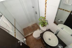uma casa de banho com um lavatório, um WC e um espelho. em Milán, Acogedor apto en Zona Rosa con Balcón em Manizales