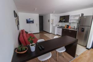 cocina y sala de estar con mesa y sillas en Milán, Acogedor apto en Zona Rosa con Balcón, en Manizales