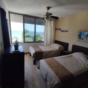 Bella Beach Condo Vacation 2 bedrooms في كانكون: غرفة فندقية بسريرين ونافذة كبيرة