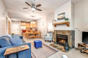 a living room with a blue couch and a fireplace at Cozy Crestview Condo in Park City