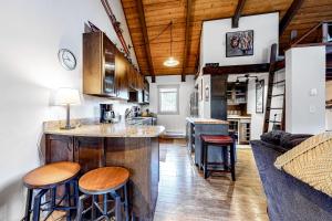 a kitchen and living room with a counter and stools at Glacier & Ducks Unlimited in Big Sky