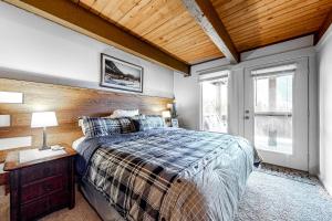 1 dormitorio con cama y techo de madera en Glacier & Ducks Unlimited, en Big Sky