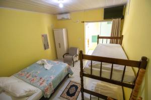 ein kleines Schlafzimmer mit 2 Etagenbetten und einem Stuhl in der Unterkunft Pousada Dalmar in Penha