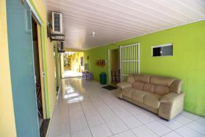 ein Wohnzimmer mit einem Sofa und einer grünen Wand in der Unterkunft Pousada Dalmar in Penha