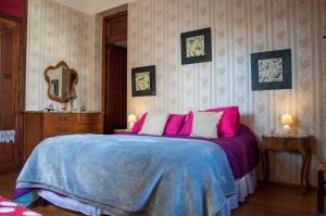 a bedroom with a bed with pink and blue sheets at Cane B&B in Montevideo