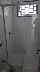 馬蒂尼奧斯的住宿－Excelente apto em Caiobá a 3 quadras da praia!，带淋浴和卫生间的白色浴室