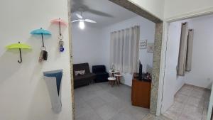 a living room with two umbrellas hanging on the wall at Rota 013 - Santos Canal 4 in Santos