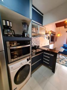 uma pequena cozinha com uma máquina de lavar louça e uma máquina de lavar roupa em Apto Duplex, Peró - Cabo Frio. Conforto, Piscina, Beira Mar. em Cabo Frio