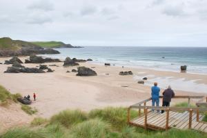 a group of people standing on a beach at Durness Youth Hostel in Durness