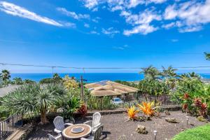 a patio with a table and chairs and the ocean at Walua Trail Estate in Kailua-Kona
