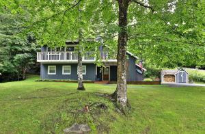 a blue house with a white deck and a yard at Chalet at the Base of Okemo Mountain in Ludlow