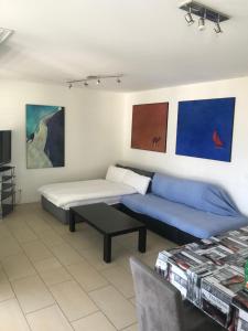 Habitación con 2 camas, sofá y pinturas. en Attico Bellavista en Locarno