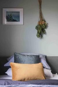 1 dormitorio con 1 cama con una planta colgada de la pared en Lylah’s By The Sea, en Wynyard