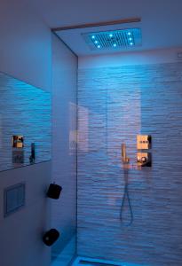 bagno con doccia con luci blu di Aparthotel Duomo a Milano