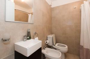 a bathroom with a white toilet and a sink at Edificio Miradores del Beagle in Ushuaia