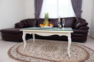 a coffee table with a bowl of fruit on top of a couch at Prima Villa Guest House in Vinnytsya