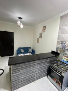 a kitchen with a stove and a couch in a room at Rayan Apartment in Hurghada