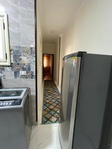 a kitchen with a stainless steel refrigerator and a hallway at Rayan Apartment in Hurghada