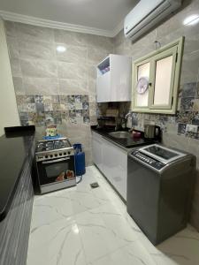 a small kitchen with a stove and a sink at Rayan Apartment in Hurghada