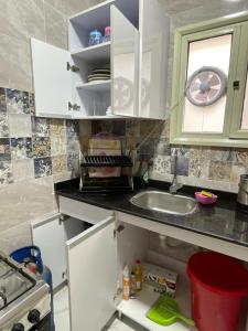 a kitchen with a sink and a clock on the wall at Rayan Apartment in Hurghada
