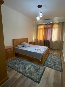 a bedroom with a bed and two rugs at Rayan Apartment in Hurghada