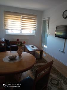 un soggiorno con tavolo e vaso sul tavolo di Mercy Deluxapartment a Visoko