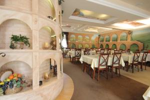 a dining room with tables and chairs and a fireplace at Villa Martini in Międzyzdroje