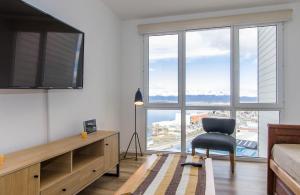 a living room with a chair and a large window at Edificio Miradores del Beagle in Ushuaia