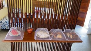 a table with four plastic containers of different types of food at Pousada Azul Blue in Amontada