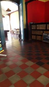 a room with a checkered floor and a red wall at Hostal Vacaciones Nicas in León