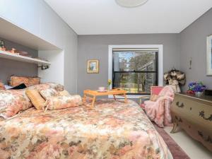 a bedroom with a bed and a table and a window at Lovett in Mittagong