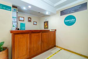 a waiting room with a wooden counter and a sign on the wall at Ayenda La Antigua in Tunja