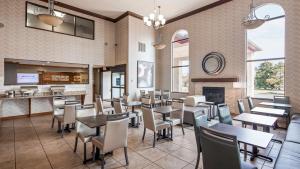 un restaurant avec des tables, des chaises et une cheminée dans l'établissement Best Western Plus North Canton Inn & Suites, à North Canton