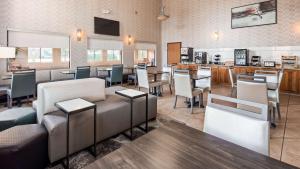a restaurant with tables and chairs and a bar at Best Western Plus North Canton Inn & Suites in North Canton