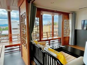 a room with a balcony with a couch and windows at The Lantern Hatyai Hotel in Hat Yai
