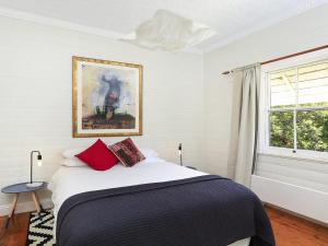 Un dormitorio con una cama y un cuadro en la pared. en Poppy Cottage, en Exeter