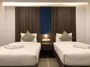 two beds in a hotel room with two at Vista Hotel Chiang Mai - SHA EXTRA PLUS in Chiang Mai