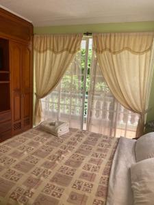 1 dormitorio con cama y ventana grande en Posada Natytali, en San Andrés