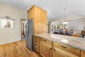 una cocina con nevera de acero inoxidable y armarios de madera en Gateway to the Wildside Townhouse, en Estes Park