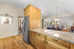 a kitchen with a stainless steel refrigerator and wooden cabinets at Gateway to the Wildside Townhouse in Estes Park