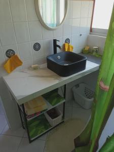 a bathroom with a black sink and a mirror at Auberge du Cap in Cilaos +56 photos