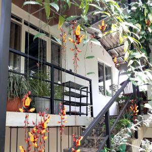 a house with a balcony with flowers on it at Dhanudi Homestay in Ella