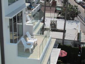 uma varanda de uma casa com duas cadeiras e uma mesa em The Front Hotel and Apartments em Praia de Patong