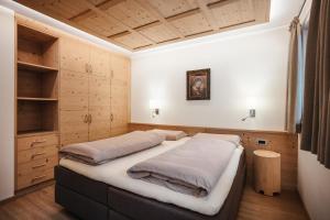 ラ・ヴィッラにあるNatur Luch Sossachのベッド2台 木製の壁の部屋
